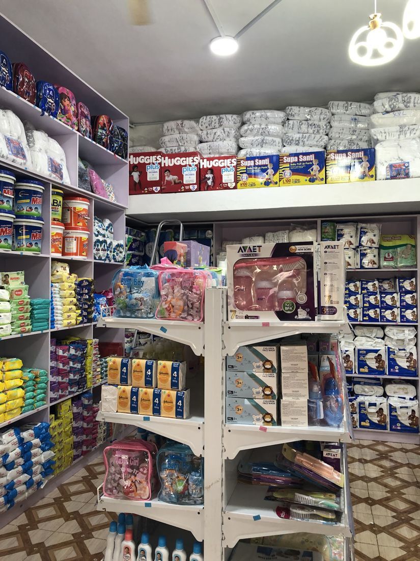 Inside the shop: diapers stacked high, baby gift bags and feeding sets